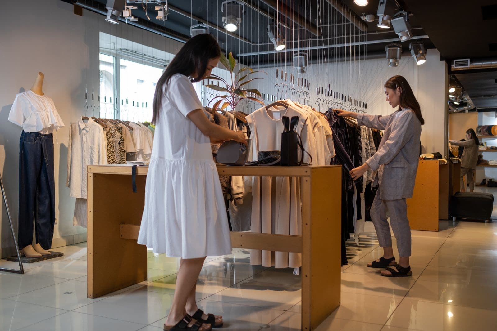 Shoppers browsing a clothing rack in a boutique store